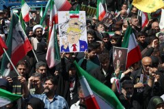 AFP/Getty Images/TNS / A woman holds a poster mocking U.S. President Donald Trump while others hold portraits of Iran's slain supreme leader Ayatollah Ali Khamenei and his son and successor Mojtaba Khamenei during a rally to commemorate his death in Tehran, Iran, on Thursday, April 9, 2026.