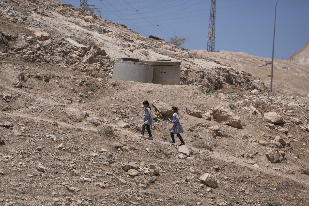 Palestinian students walk on their way home after receiving their year end reports from school, in the West Bank Bedouin hamlets of Khan al-Ahmar, Wednesday, June 10, 2026. (AP Photo/Mahmoud Illean)