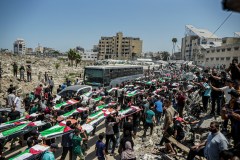 Faiz Qreqa/Middle East Images/AFP/Getty Images/TNS / Mourners carry bodies wrapped in Palestinian flags during a mass funeral procession in Gaza City, Gaza Strip, on Aug. 4, 2026. The remains of 112 members of the Abu Sharia and Al-Hasayneh families were recovered from the rubble of their home following an Israeli strike.