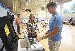 Staff photo by Matt Hamilton / Sharon Ford looks on as Reece Nixon casts his ballot at the Patten Community Center on Thursday, Aug. 6, 2026.