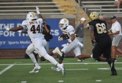 Staff Photo by Matt Hamilton / UTC defensive back Jaden Nelson tucks the football in as he returns an interception for a touchdown while defensive tackle C.J. Smith (44) cheers him on during a SoCon game against Wofford on Sept. 19 at Finley Stadium.