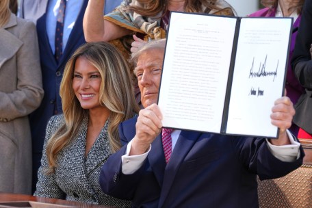 President Donald Trump holds up a signed executive order alongside first lady Melania Trump at an event about women's health, in the Rose Garden of the White House, Monday, Oct. 19, 2026, in Washington. (AP Photo/Alex Brandon)