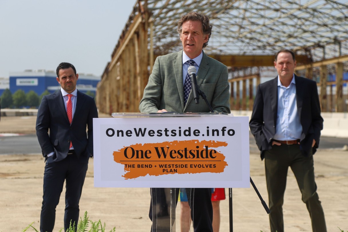 Staff File Photo / Chattanooga Mayor Tim Kelly speaks in 2023 at a gathering to announce One Westside, a plan for The Bend and the Westside community. More than three years later, Kelly and Hamilton County Mayor Weston Wamp (left) met with lead developer Jimmy White (right) to talk about moving the project forward.